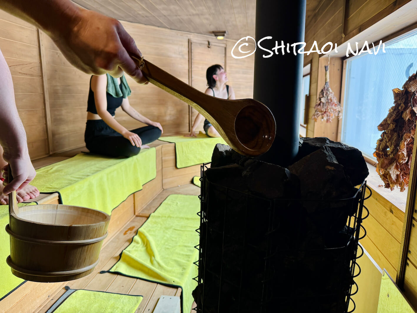 北海道白老町ASOBUBAのアソブサウナでサウナストーンにロウリュ水をかける手元のアップ