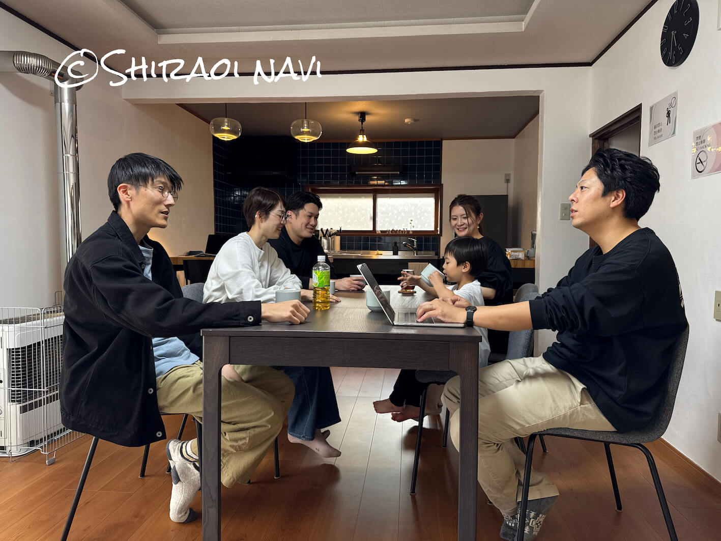 白老の貸別荘「Shiraoi Villa Auty」のリビングダイニングで過ごす宿泊風景。大きなテーブルを囲みながら、グループやファミリーでゆっくり会話や食事を楽しめる、一棟貸しならではの空間。